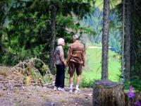 Ældre par står hånd i hånd ude i naturen 